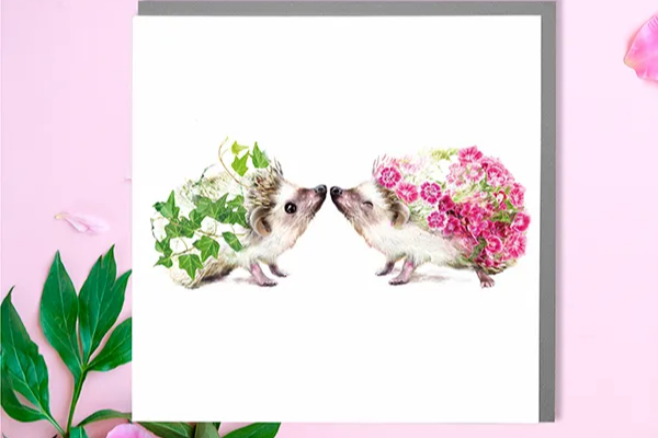 two hedgehogs with flowers on a greeting card lola design 